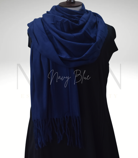 Navy blue scarf with fringe on a black dress against a white background
